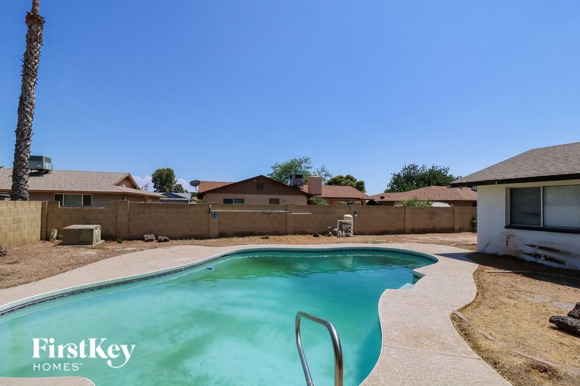 a swimming pool in a backyard with a house