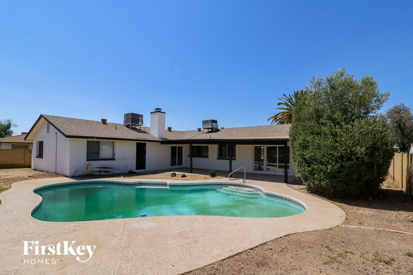 a backyard with a pool and a white house