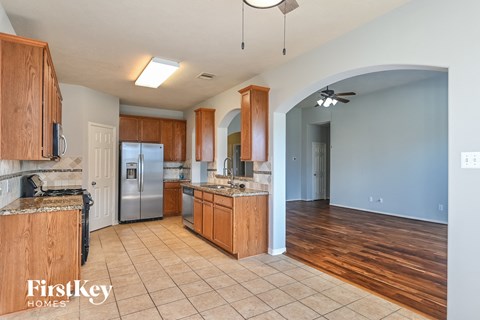 A kitchen with wooden cabinets and a refrigerator.