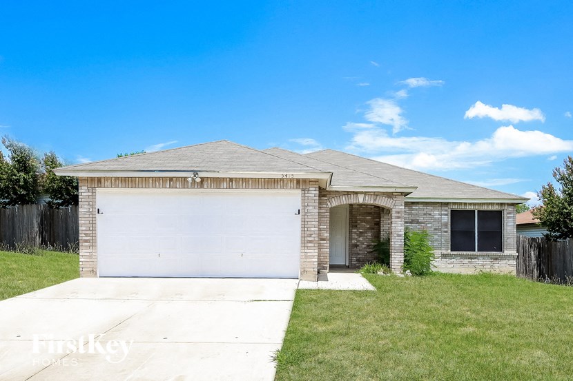 A house with a garage door and a driveway.