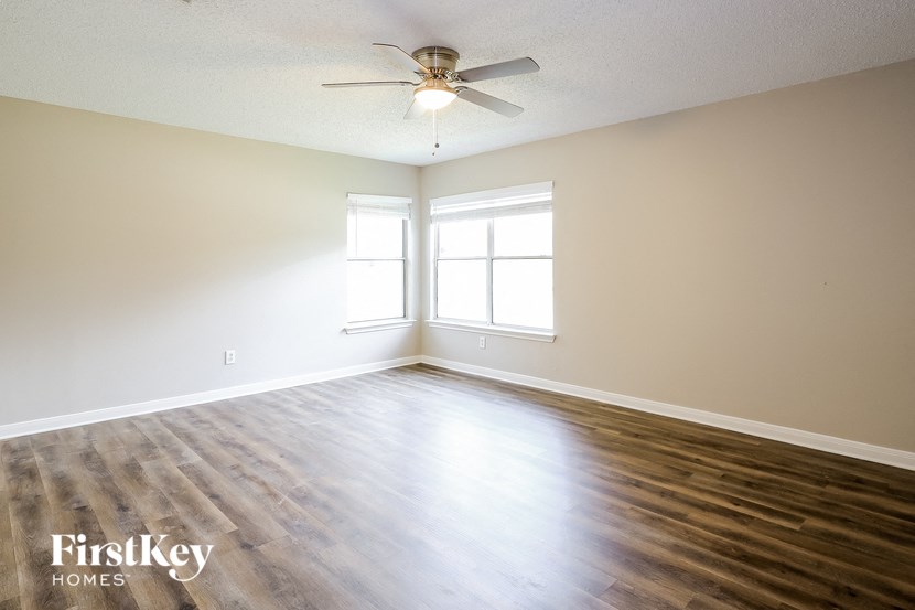 A room with a ceiling fan and a window.