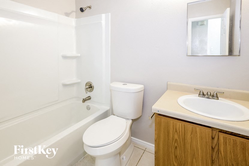 A white toilet sits next to a white sink in a bathroom.