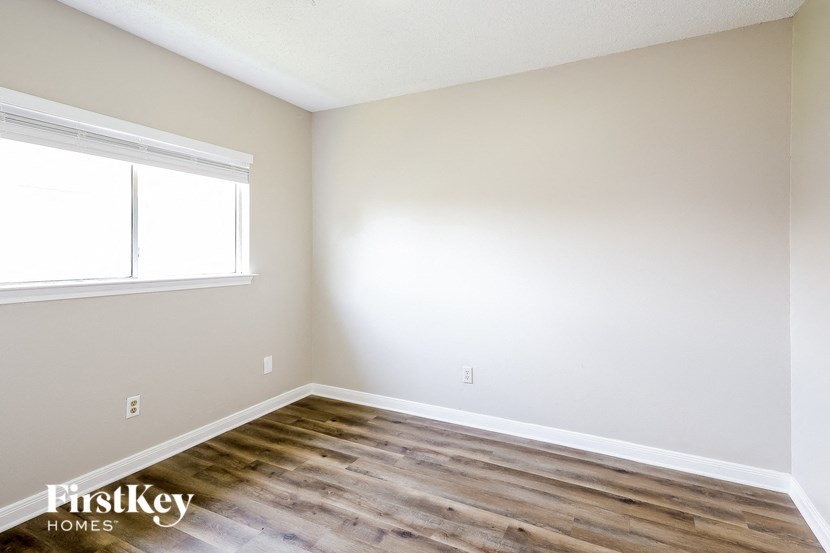 A room with wooden flooring and a window letting in natural light.