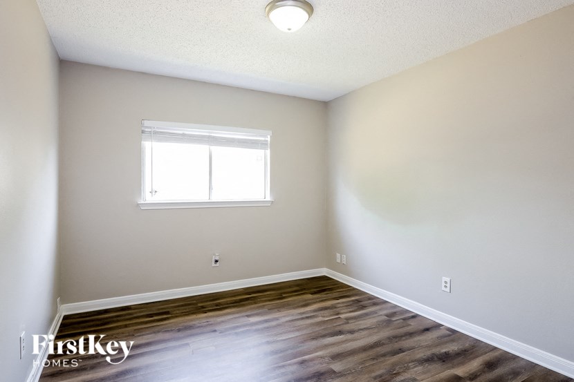 A room with a window and wooden floors.