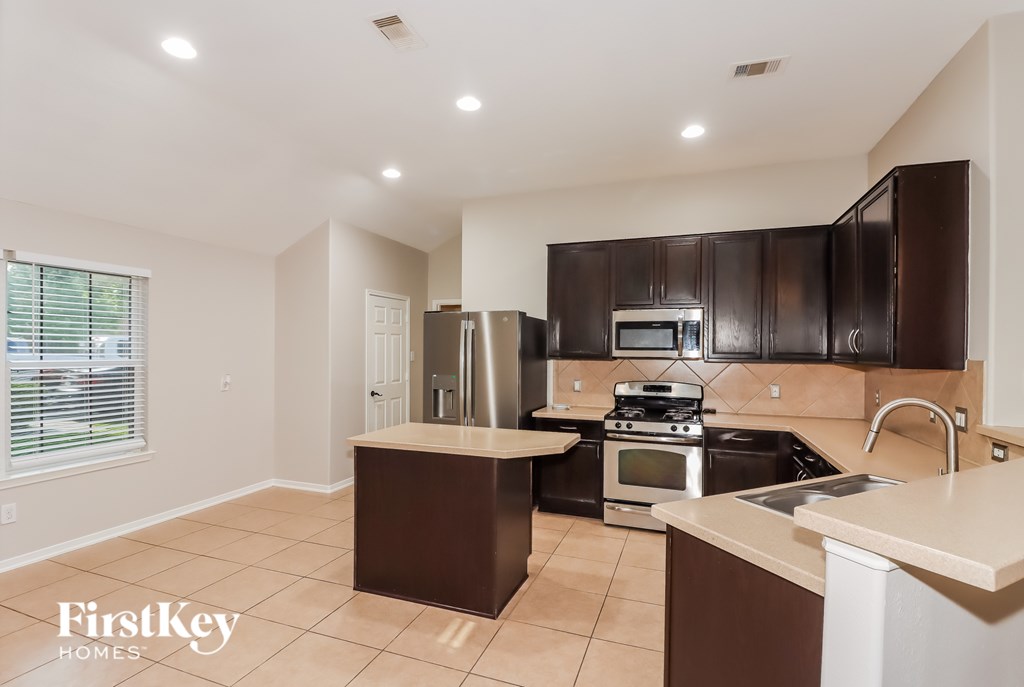 A kitchen with brown cabinets and a white countertop.