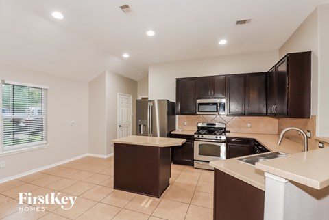 A kitchen with brown cabinets and a white countertop.