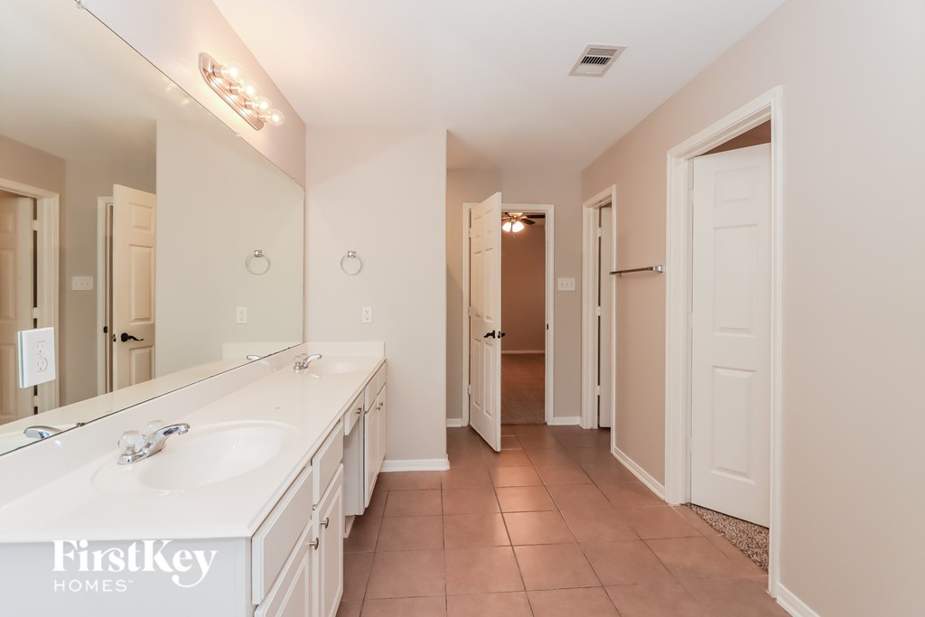 A bathroom with a double sink vanity and a large mirror.