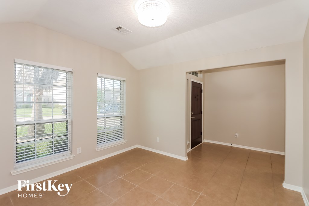 A room with a sliding door and two windows.