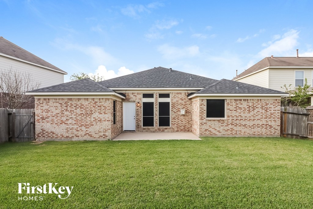 A brick house with a white door and windows is for sale.