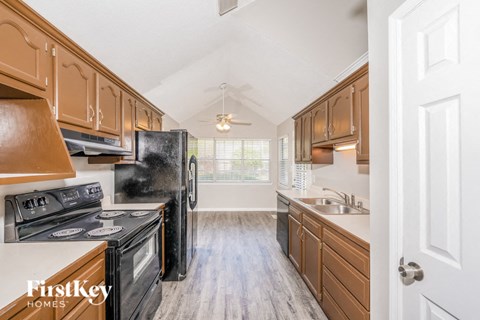 A kitchen with wooden cabinets and black appliances.