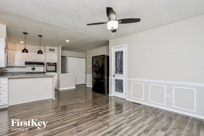 an empty kitchen and living room with a ceiling fan