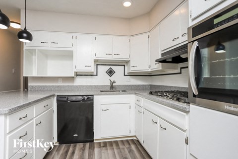a kitchen with white cabinets and stainless steel appliances