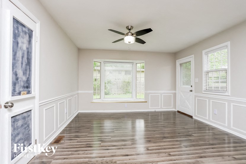 an empty living room with white walls and a ceiling fan