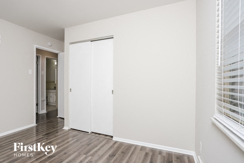 the living room of a home with white walls and wood floors
