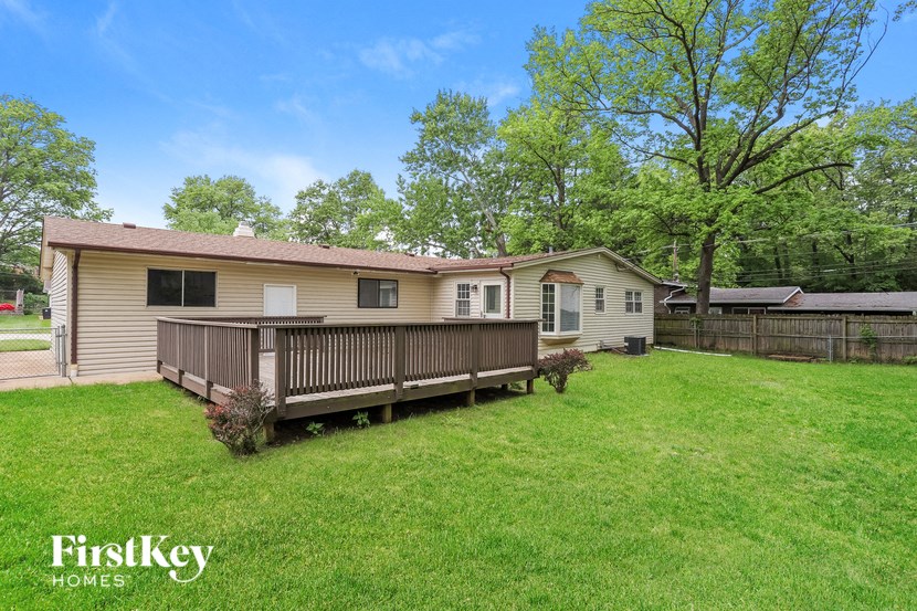 a house with a deck and a grassy yard