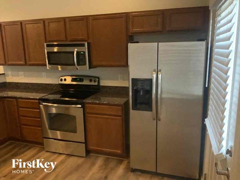A kitchen with a stainless steel refrigerator and a stove top oven.