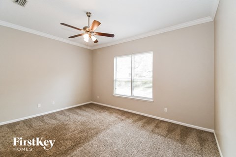 a living room with carpet and a ceiling fan
