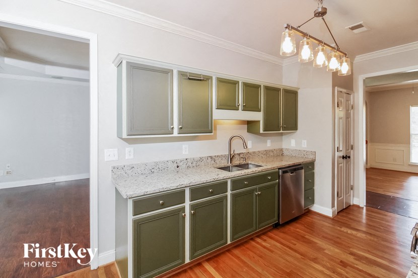 a kitchen with green cabinets and a marble counter top