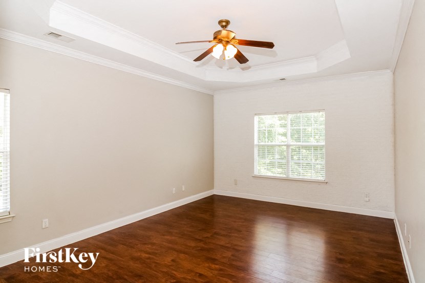 a empty room with wooden floors and a ceiling fan