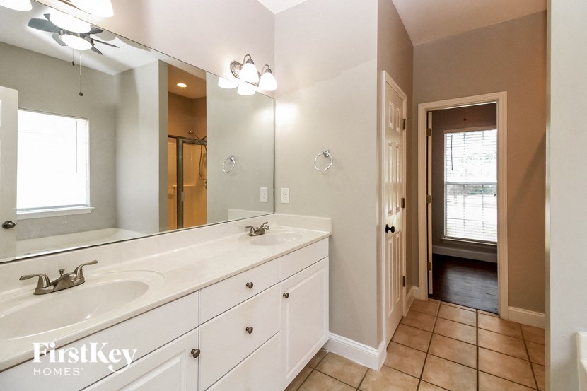 the master bathroom has a large mirror and a large sink