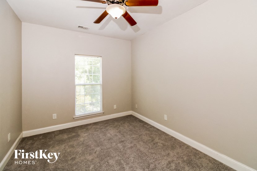 a bedroom with carpet and a ceiling fan
