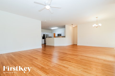 A room with wooden floors and a ceiling fan.