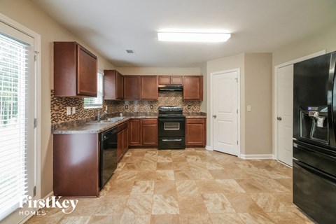 A kitchen with brown cabinets and a tiled floor.