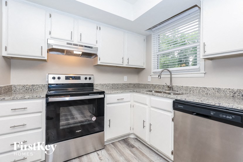 A modern kitchen with white cabinets and stainless steel appliances.