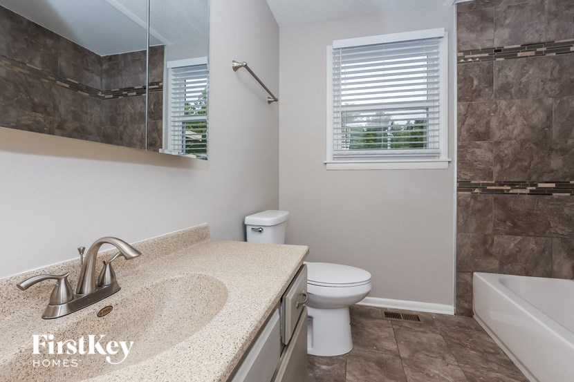 A bathroom with a sink, toilet, and tub.