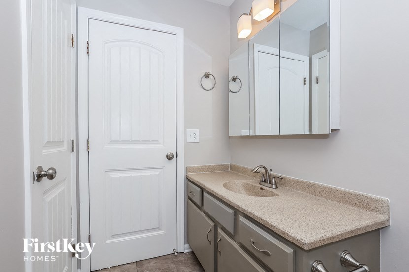 A bathroom with a sink, mirror, and medicine cabinet.
