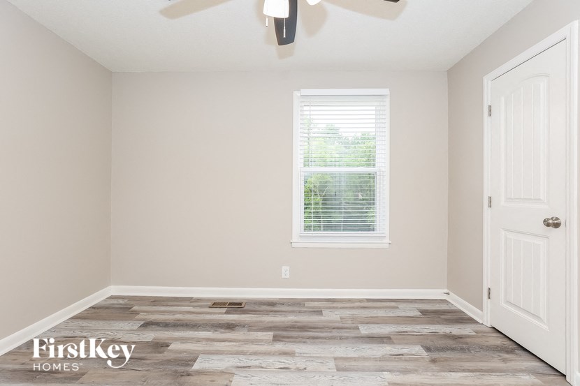 A room with a wooden floor and a ceiling fan.