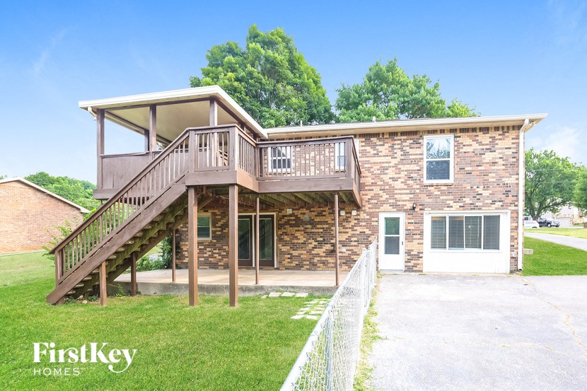 A brick house with a wooden staircase leading to the second floor.