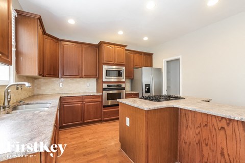 A kitchen with wooden cabinets and a marble countertop.