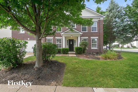 A brick house with a tree in front of it.