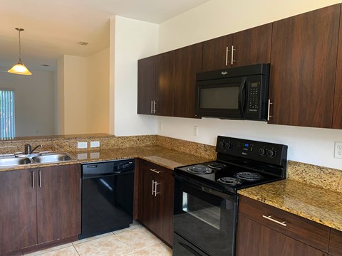 a kitchen with black appliances and a granite counter top