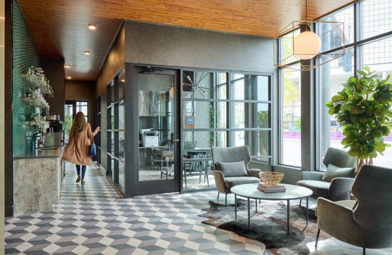 a woman walking into a lobby with chairs and tables