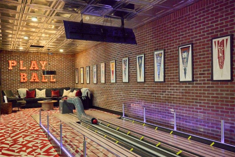 a bowling alley with a man sitting on a bench