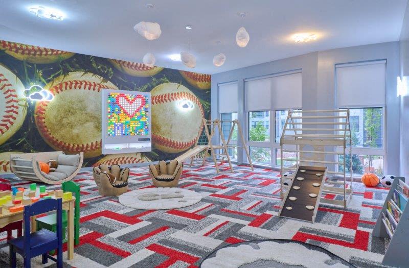 a childrens play room with a slide and a baseball theme
