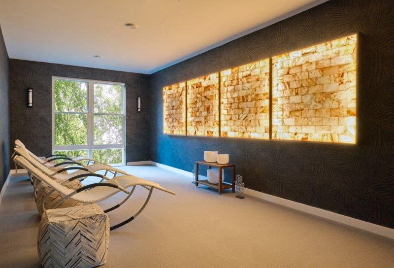 a relaxation room with chairs and a wall of rocks