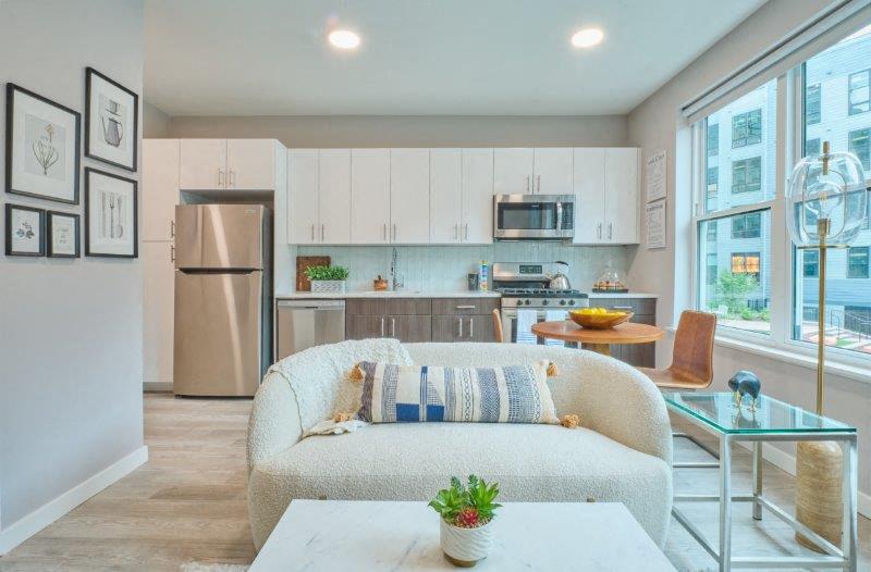 a living room and kitchen with a couch and a table