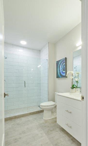 a white bathroom with a toilet and a shower