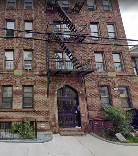 the front of a brick building with a fire escape