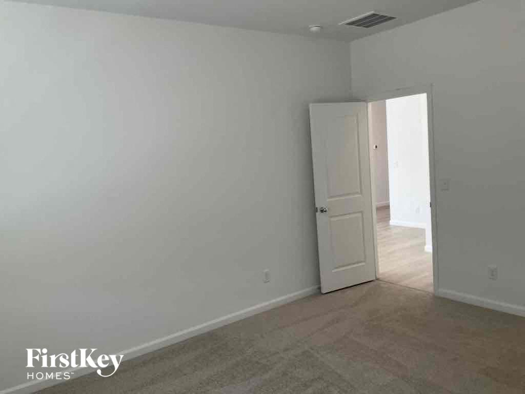 an empty living room with white walls and a door to a hallway