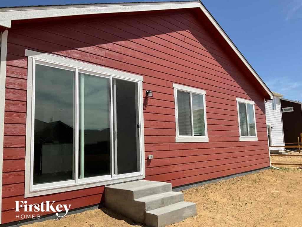 a red house with a large window and steps in front of it