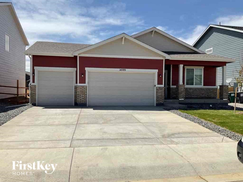 the front of a house with a driveway and a garage door