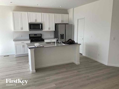 an empty kitchen with white cabinets and a counter top