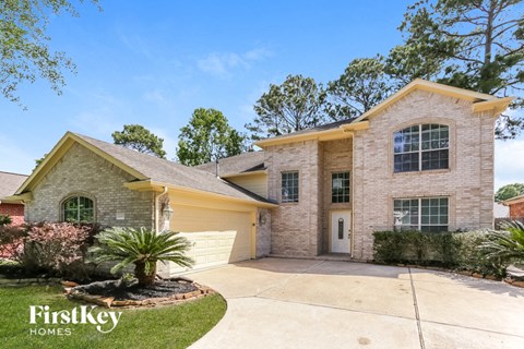 a beige brick house with a yellow garage and a driveway