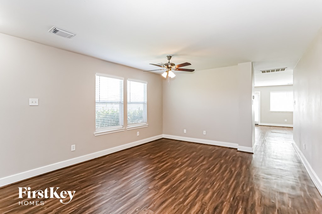 a living room with hardwood flooring and a ceiling fan