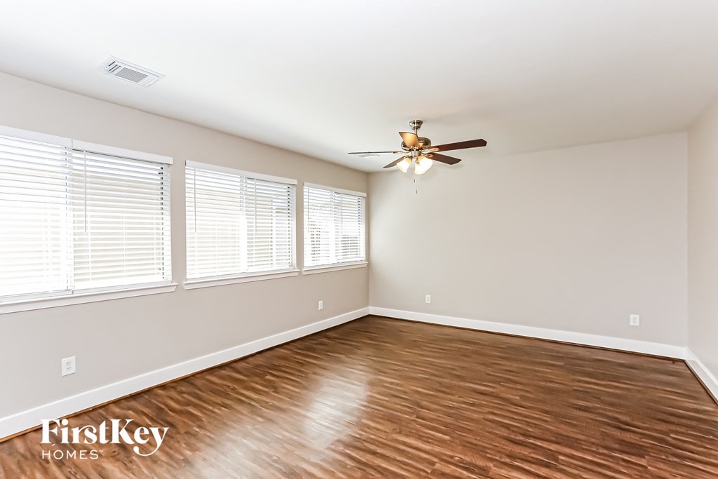a living room with wood floors and a ceiling fan