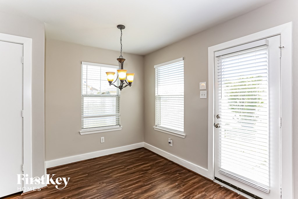 an empty room with a door and a light hanging from the ceiling
